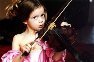 Maedchen in Kleid spielt Geige