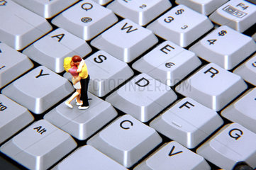 Miniaturpaar kuesst auf Tastatur