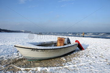 einzelnes Fischerboot an schneebedecktem Strand