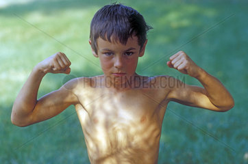 Junge zeigt Muskeln