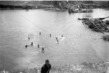 Soldaten baden in Fluss neben zerstoerter Bruecke