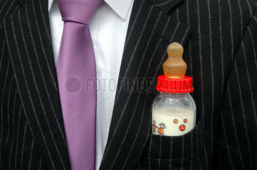 Mann mit Babyflasche im Anzug
