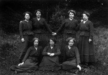Sieben Frauen posieren vor der Kamera
