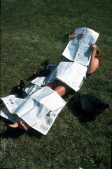 Nackte Frau bedeckt mit Zeitungen