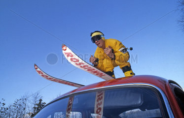 Skifahrer auf Autodach