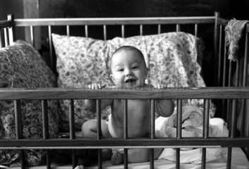 Baby im Gitterbett