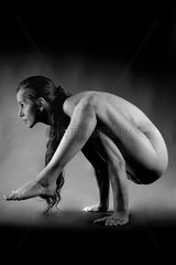 nackte Frau macht akrobatische Figur