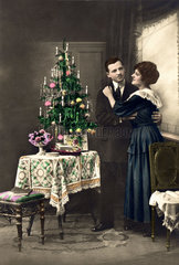 Paar umarmt sich Weihnachten Baum