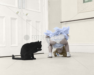 Maedchen spielt mit schwarzer Katze