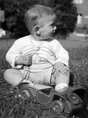 kleiner Junge spielt mit Holzauto