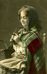 1920 Maedchen verkleidet als Oma strickt