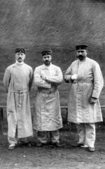 Drei Maenner in gestreifter Kleidung  1900
