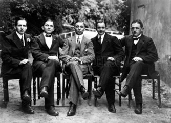 5 junge Maenner auf Stuehlen sitzend  1910