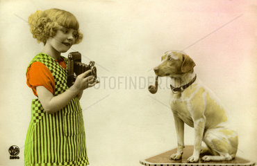 Maedchen fotografiert Hund mit Pfeife