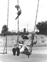 Affe und Kind auf Schaukel