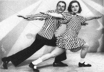 Paar in gestreifter Kleidung tanzt
