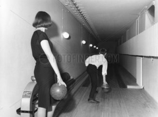 Mann und Frau in enger dunkler Bowlingbahn