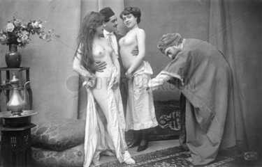 Zwei Maenner mit zwei nackten Frauen
