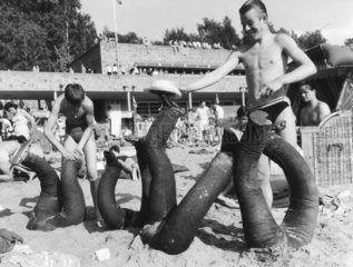vergrabene Jugendliche - Beine mit Jeans schauen aus dem Sand
