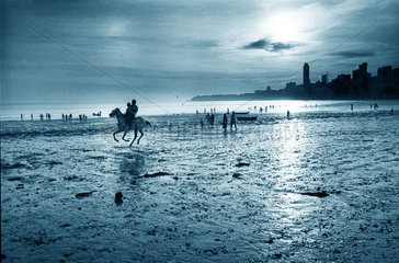 Indien - Spaziergaenger und Reiter am Strand von Bombay