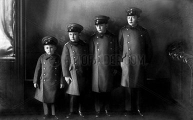 vier uniformierte Jungen der Groesse nach aufgestellt