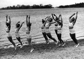 Frauen machen Gymnastik am Strand  1930