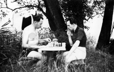 zwei Maenner spielen Schach im Freien