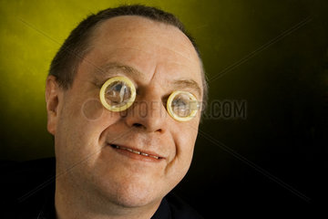 Mann mit Kondomen auf den Augen