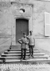 zwei Soldaten auf Treppen vor Hauseingang