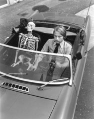 Skelett and Mann fahren Auto