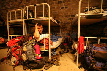 Pilger mit Schlafsack im Doppelstockbett in Herberge