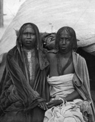 zwei afrikanische Frauen vor Haus