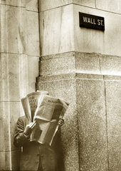 Mann liesst Zeitung auf der Wall Street