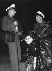 Motorradpolizist und Polizist untehalten sich