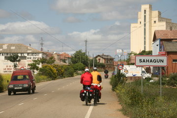 Fahrradfahrer auf dem Jakobsweg fahren in Ortschaft - Camino de Santiago