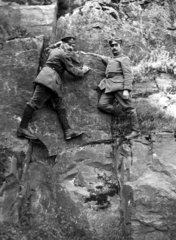 Zwei Soldaten klettern am Felsen