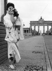 Jaspanerin in Kimono und mit Kamera vor Brandenburger Tor