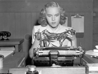 Frau verzweifelt an der Schreibmaschine
