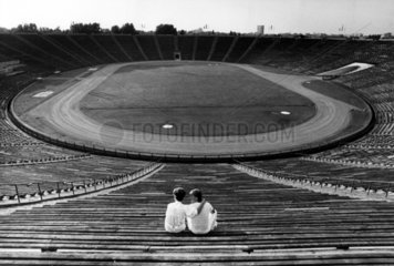 zwei Zuschauer in leerem Fussballstadion
