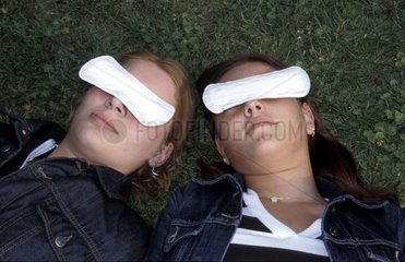 Zwei Frauen mit slipeinlagen ueber den Augen