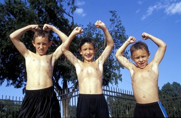 Drei Jungs zeigen ihre Muskeln