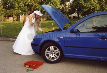 Frau in weissem Kleid hat Motorschaden