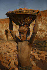 Child worker carrying bricks