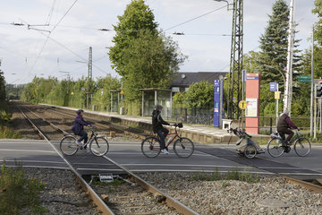 Fahrradfahrer passieren Bahnuebergang