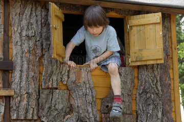Berlin  ein Junge klettert aus dem Fenster eines Baumhauses
