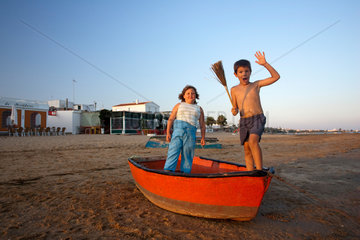 El Rompido  Spanien  Kinder albern in einem Fischerboot am Strand