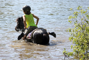 Oberoderwitz  Maedchen turnt auf ihrem Pony in einem See
