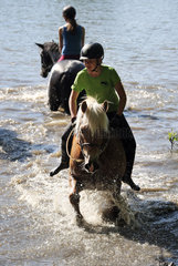 Oberoderwitz  Maedchen baden mit ihren Pferden in einem See