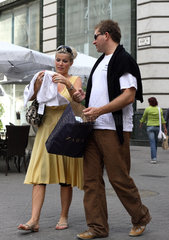 Frau zeigt Mann die gekaufte Kleidung von Zara in Budapest