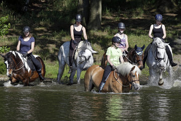 Oberoderwitz  Maedchen reiten mit ihren Pferden in einen See
